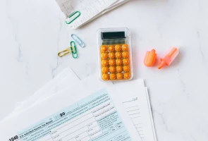 Tax form, calculator, and office supplies on desk